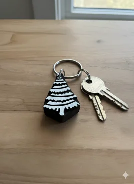 Porte-clés artisanal en bois sculpté indien en forme de sapin avec des clés sur une surface en bois