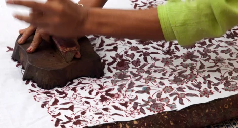 Artigiana che stampa un motivo floreale in India